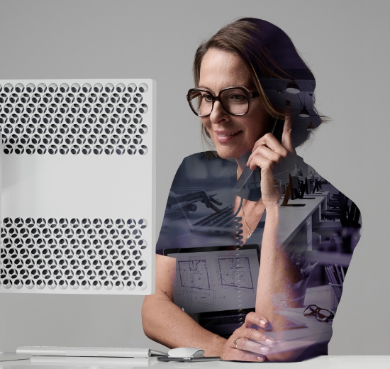 Frau mit Brille sitzt am Schreibtisch und blickt in Ihren Bildschirm. 